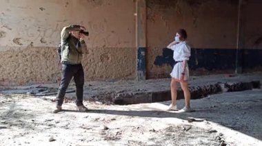 Bir adamın açık havada bir kızın fotoğrafını çekerken çekilmiş görüntüler. 