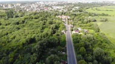 Güneşli bir günde güzel bir sonbahar ormanı yakınında otobanı olan şehir manzarası.