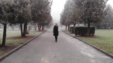 Kış parkında yürüyen bir kadının görüntüleri.