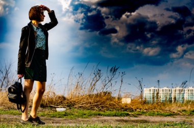 Güneşli bir günde çayırda poz veren güzel ve çekici bir kadın. 