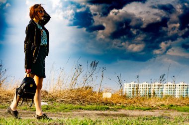 Güneşli bir günde çayırda poz veren güzel ve çekici bir kadın. 