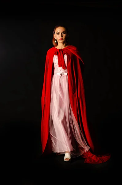 暗い背景に赤いマントの美しい女性劇的で素晴らしい撮影 — ストック写真