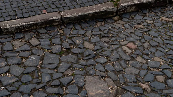 view of gray textured sidewalk tile at street