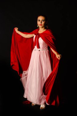 Koyu arkaplanda kırmızı pelerinli güzel bir kadın dramatik ve fantastik bir çekim 