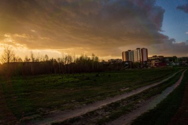 Günbatımı gökyüzünün altında bulutlu yeşil çayır