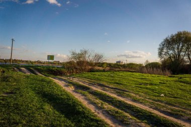 Günbatımı gökyüzünün altında bulutlu yeşil çayır