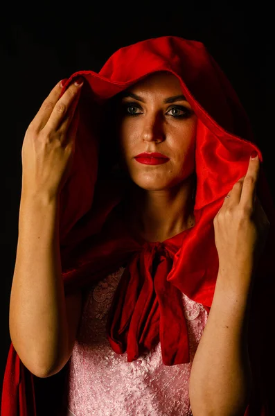 beautiful woman in red cloak  on dark background Dramatic and fantastic shooting