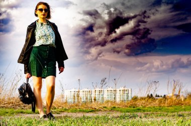 Güneşli bir günde çayırda poz veren güzel ve çekici bir kadın. 