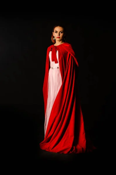 暗い背景に赤いマントの美しい女性劇的で素晴らしい撮影 — ストック写真