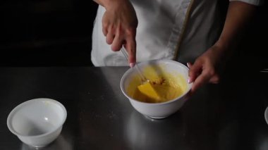 Kadınların elleri yumurta bir şekerleme fabrikada çırpma teli ile yendi