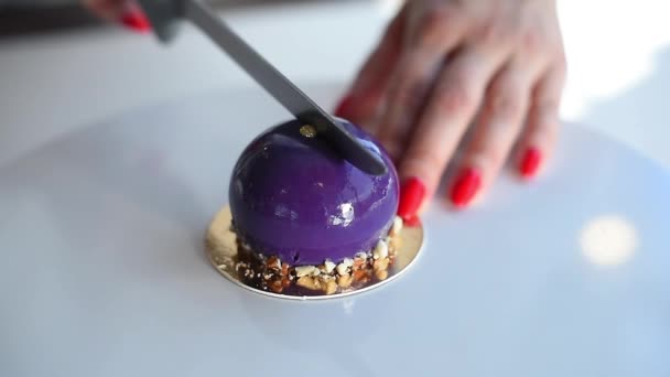 Mano femenina cortando un pastel púrpura en una mesa blanca. Pastel de mousse. Delicioso postre — Vídeos de Stock