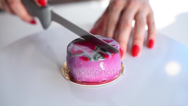 Vrouwelijke hand een roze cake snijden op een witte tafel. Mousse taart. Heerlijk dessert — Stockvideo