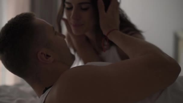 Un ragazzo con una ragazza che si diverte a letto. amore giochi, amanti del gioco. giochi d'amore a letto. forti abbracci e risate — Video Stock