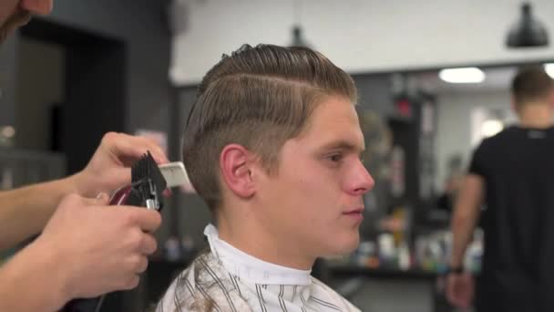 Peluquero corta el pelo de los clientes. vista lateral — Vídeos de Stock