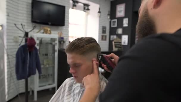 Парикмахер стрижет волосы клиентов. вид сбоку — стоковое видео