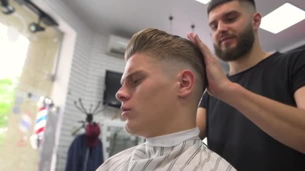 Barber combs the client, makes the packing on the head for the client. end of service — Stock Video