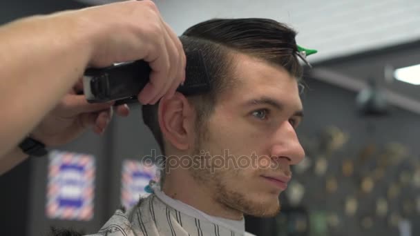 Peluquero corta el pelo de los clientes. vista lateral — Vídeos de Stock