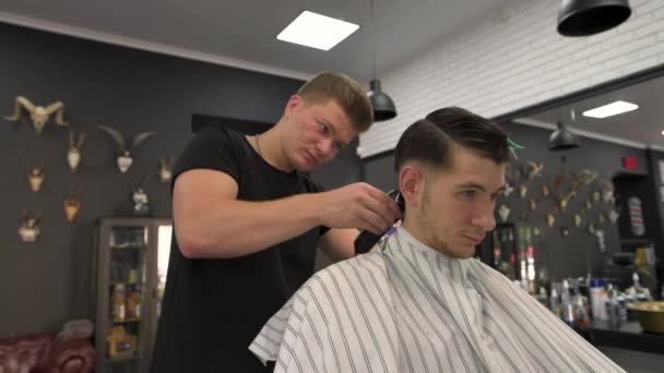 Friseur schert den Kunden die Haare. Seitenansicht — Stockvideo