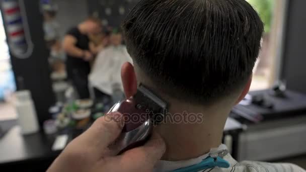 Peluquero corta el pelo de los clientes. vista lateral — Vídeos de Stock