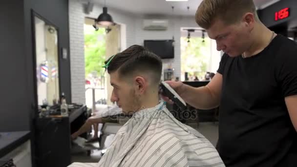 Tukang cukur menyobek rambut kliennya. tampilan samping — Stok Video