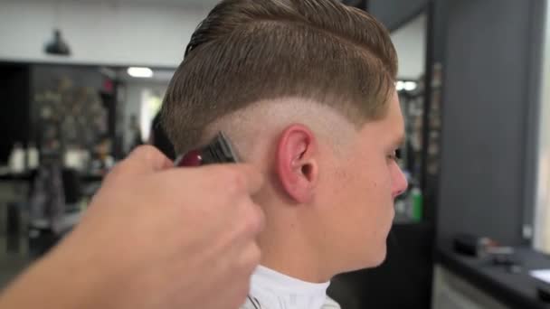 Friseur schert den Kunden die Haare. Seitenansicht — Stockvideo