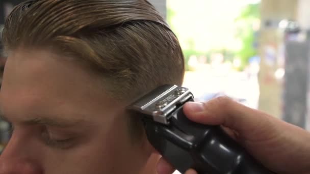 Il barbiere tosa i capelli dei clienti. vista laterale — Video Stock