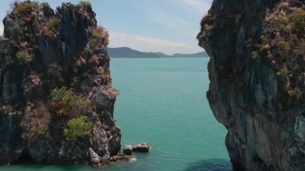 바다에서 공중 촬영 산. 두 바위 사이를 흐르는 드론. — 비디오