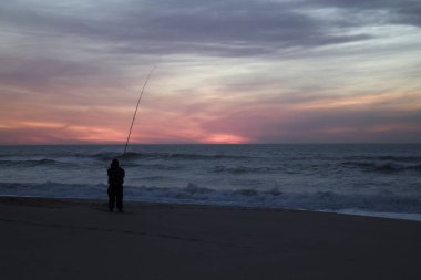 Harika, güzel günbatımı okyanus ve yalnız balıkçı. 
