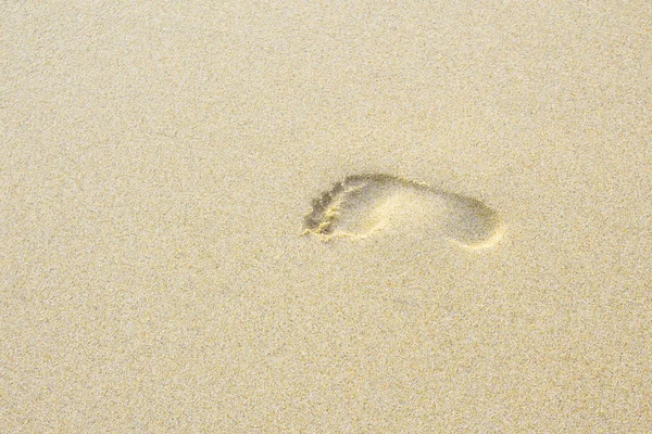 foot imprinted on the beach