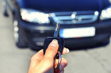 Düğme uzaktan araba üzerinde tutan el. Kadın el presleri uzaktan kumanda araba alarm sistemlerinde seçici odakta... Otomatik sigorta iş. Araba güvenlik kilit sistemi kavramı.