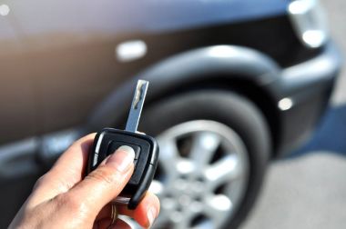 Düğme uzaktan araba üzerinde tutan el. Kadın el presleri uzaktan kumanda araba alarm sistemlerinde seçici odakta... Otomatik sigorta iş. Araba güvenlik kilit sistemi kavramı.