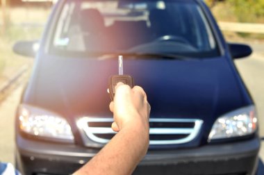 Düğme uzaktan araba üzerinde tutan el. Adam el presleri uzaktan kumanda araba alarm sistemlerinde seçici odakta... Otomatik sigorta iş. Araba güvenlik kilit sistemi kavramı. 