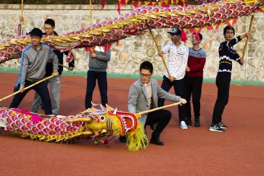 İnsanlar üzerinde Dragon Festivali dans ediyor