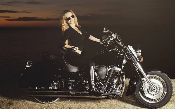 Genç güzel kadın ve günbatımı bisikletle stilize fotoğrafı 