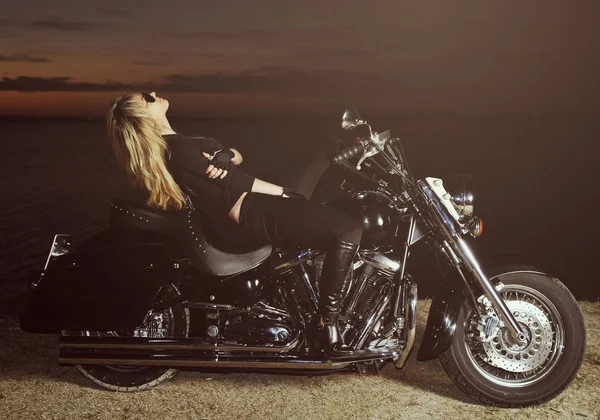Foto estilizada de la joven hermosa mujer y la bicicleta en la puesta del sol —  Fotos de Stock