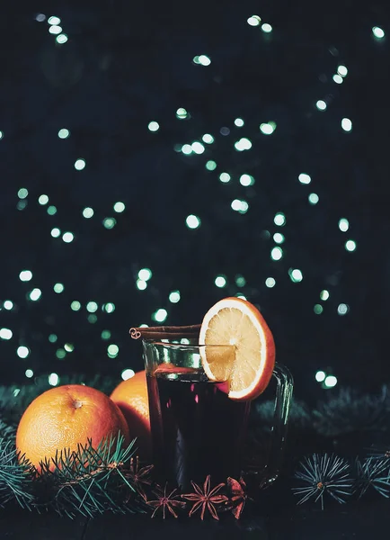 Foto estilizada de un vino caliente con especias sobre fondo navideño —  Fotos de Stock