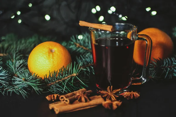 Foto estilizada de un vino caliente con especias sobre fondo navideño —  Fotos de Stock