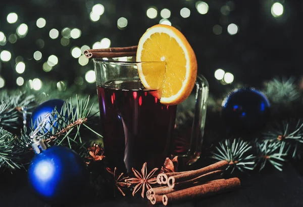 Foto estilizada de un vino caliente con especias sobre fondo navideño —  Fotos de Stock