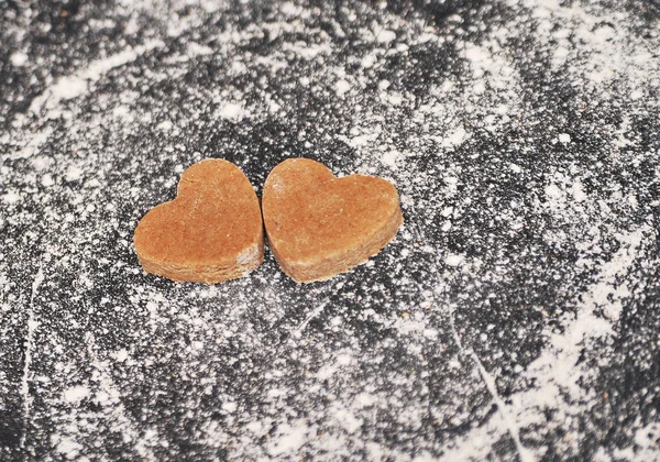 Homemade heart cookies on a black background