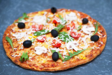 Taş zemin üzerine malzemelerle pizza.