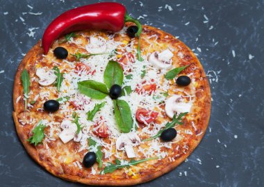 Taş zemin üzerine malzemelerle pizza.