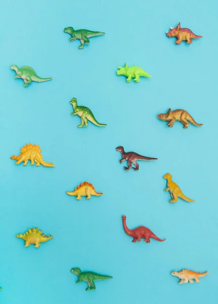 Collection of dinosaurs toys on colorful background.