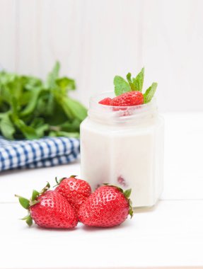 Bisküvi ve beyazi ahşap zemin üzerine çilek kremalı. 