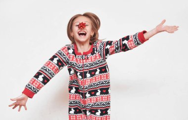 Beyaz arka planı olan pijamalı tatlı bir kız..