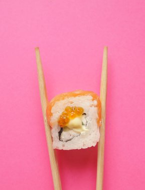 Japonlar pembe arkaplanda yuvarlanıyor.