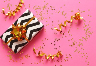 Kurdeleli hediye ve renkli arkaplanda yay.