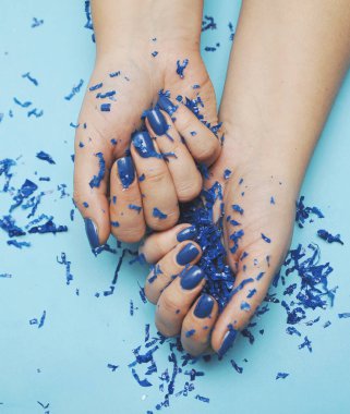 Klasik mavi manikürlü bir kadın eli. 2020 Yılı Rengi.