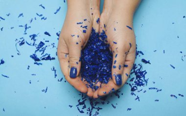 Klasik mavi manikürlü bir kadın eli. 2020 Yılı Rengi.