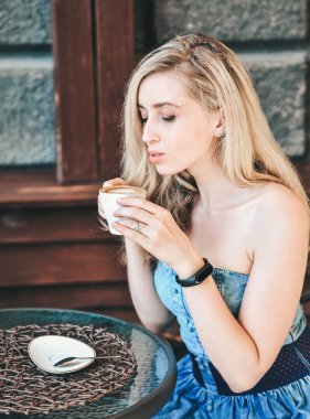 Güzel genç kadın latte fincan ile kafein poz.