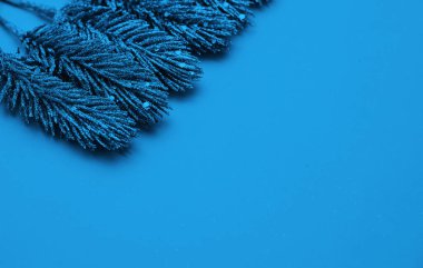 Mavi arka planda parıltılı noel ağacının dalları.